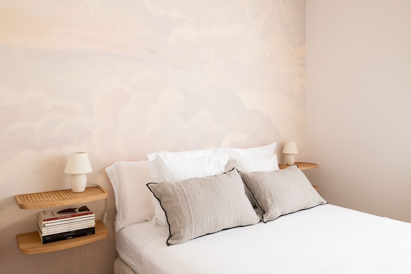 Dormitorio con mural de nubes y mesillas voladas de rejilla